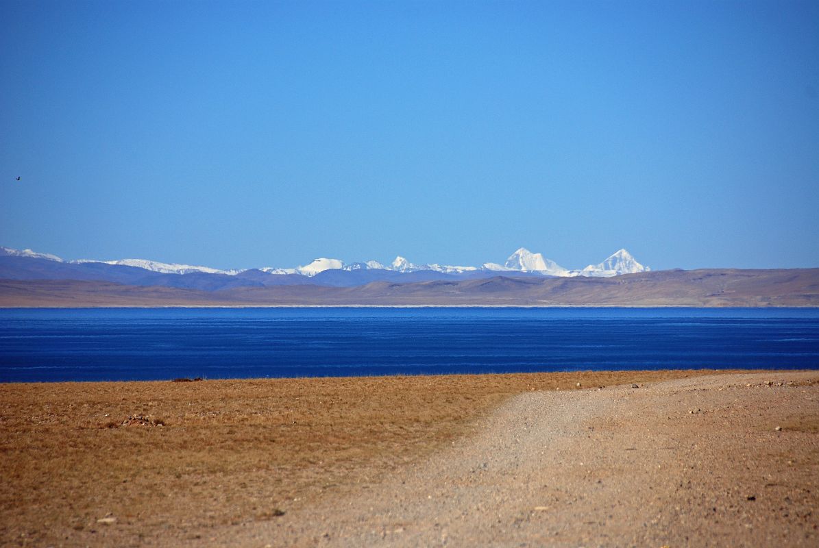 06 Lake Manasarovar And Peaks Of Indian Himalaya From First View Of Mount Kailash The Indian Himalaya stands above the blue waters of Lake Manasarovar seen from the crest of the small hill that has the first view of Mount Kailash.